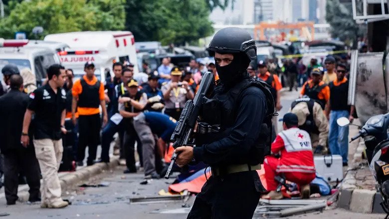 An Indonesian policeman stands guard in front of a blast site in the aftermath of the January 14 Jakarta attacks.